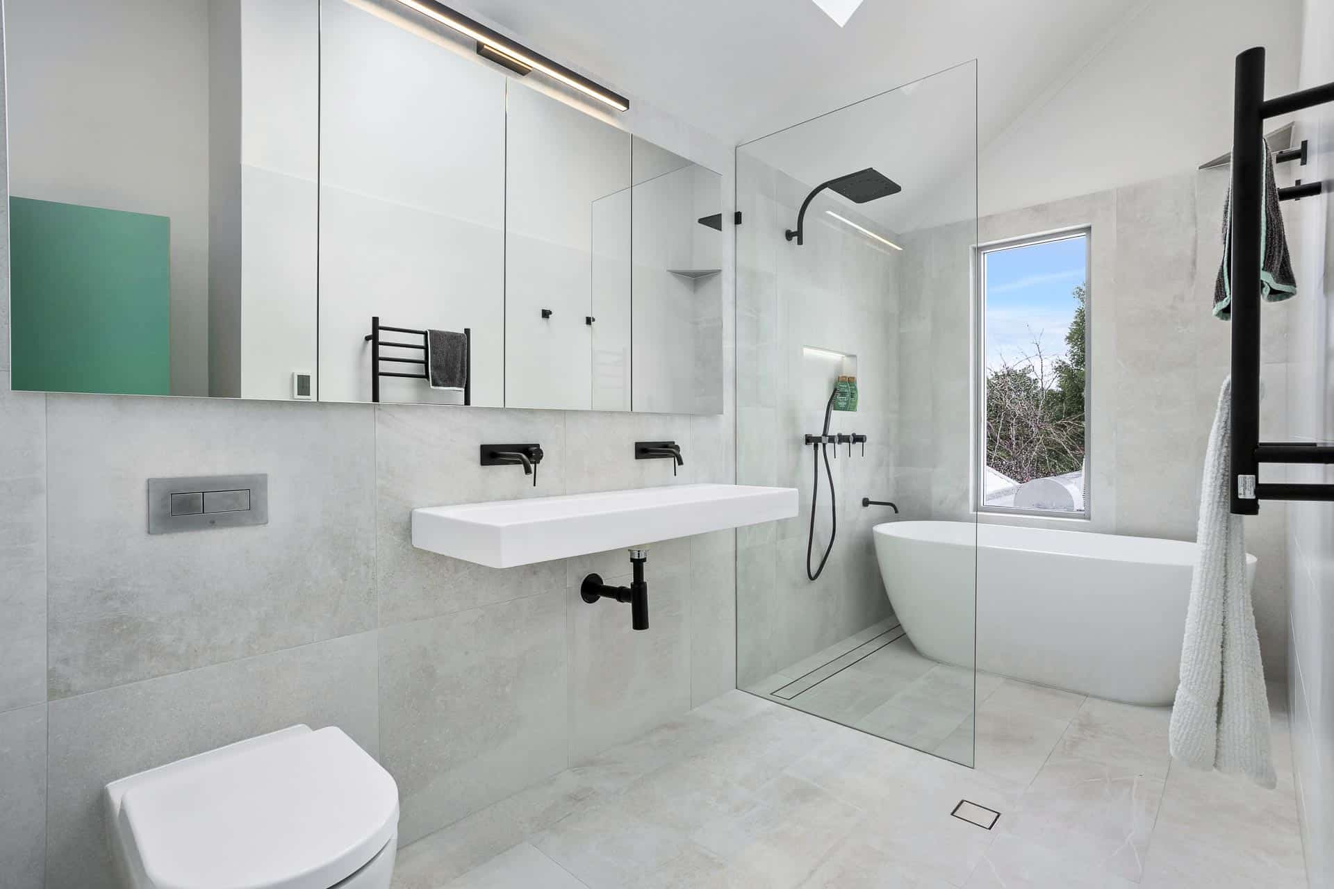 Minimalist bathroom with light gray tiles and glass shower
